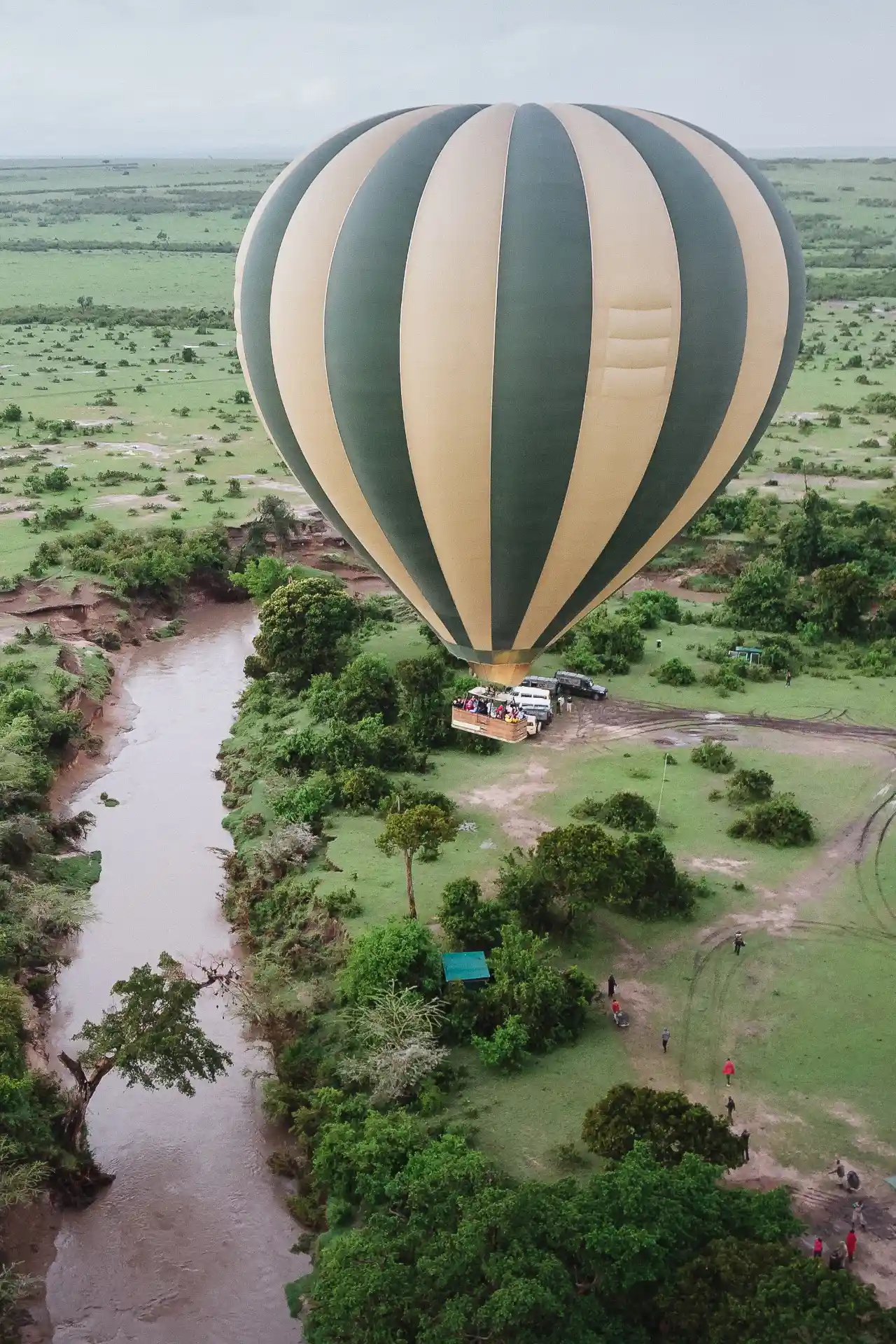 Hot air balloon drifting over a river in the Maasai Mara ecosystem near Serengeti