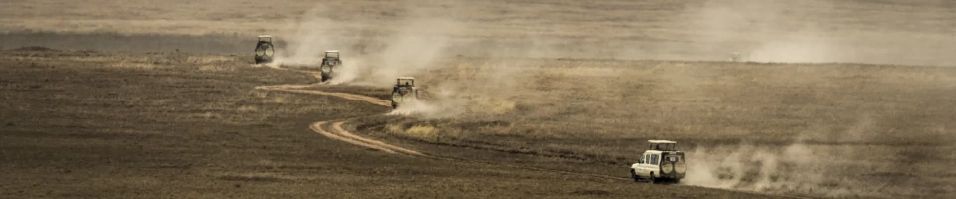 Safari jeeps crossing the vast plains of Serengeti National Park - Porcupine Tours
